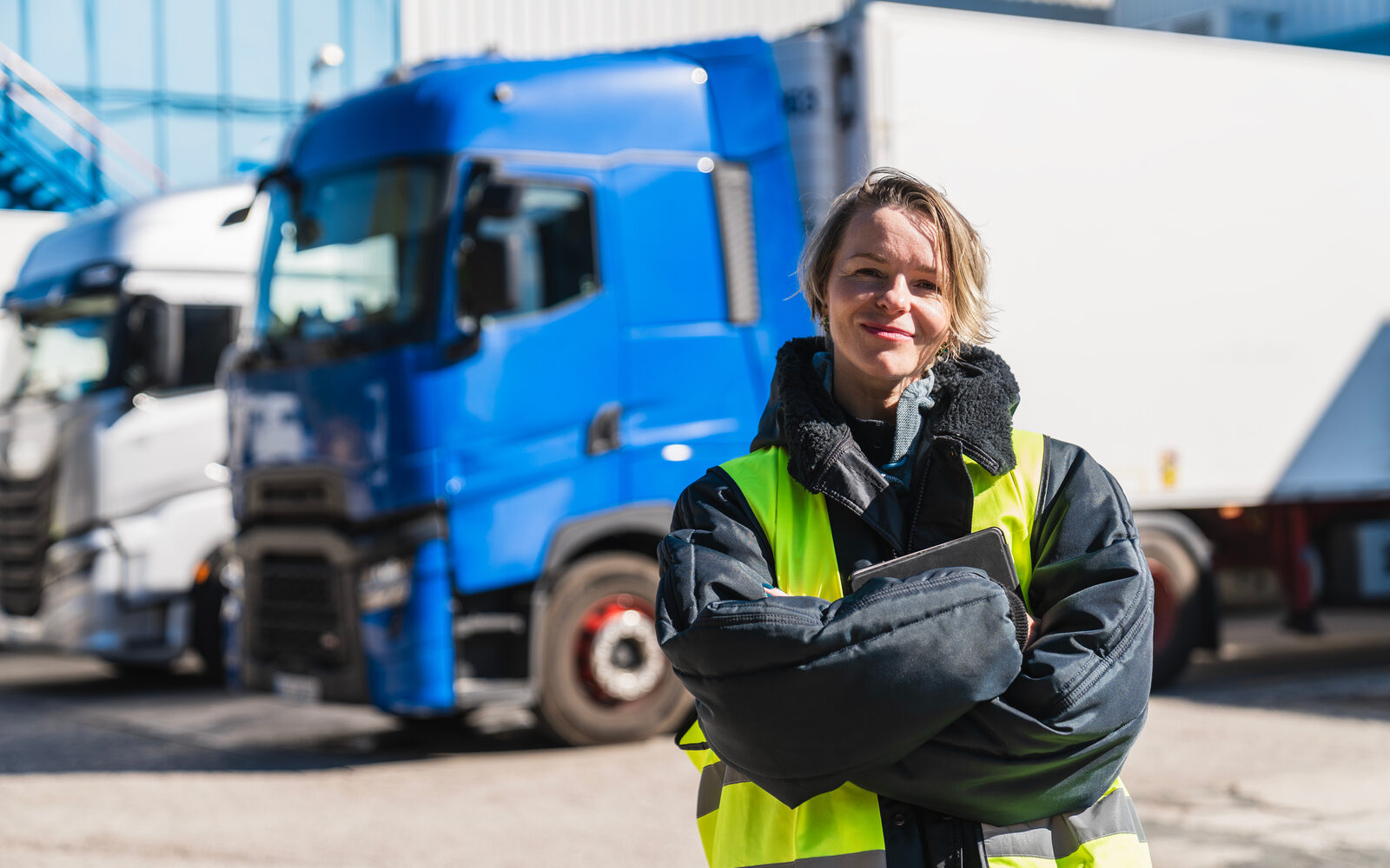 Transport manager standing near heavy goods vehicles